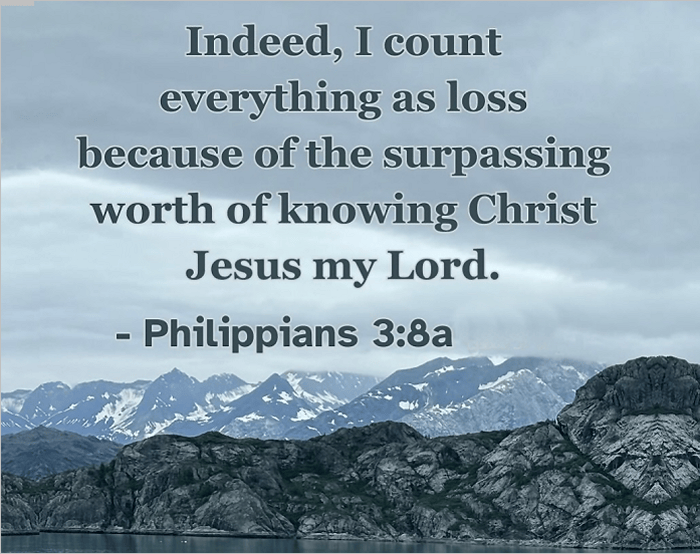A scenic mountain landscape with a quote from Philippians 3:8a emphasizing the value of knowing Christ.